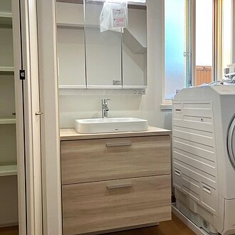 木目調で統一された温かみある洗面化粧台リフォームのイメージ