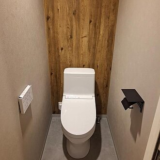木目調のクロスがアクセントに！洗練されたトイレリフォームのイメージ